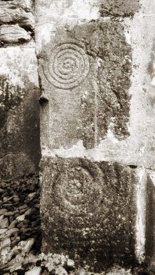 The neolithic art of spirals carved in rock form the left leg of an altar of the oldest church on Inishmore, Ireland. Pilgrimage to Ireland.
