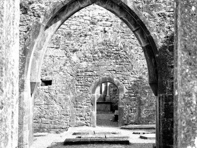 One black and white photo of multiple arches of a stone church in Shannon, Ireland on the way to Inishmore. 