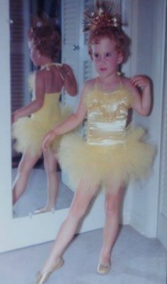 The author at age four dressed in a yellow ballet costume with yellow tutu and a gold crown on her head.